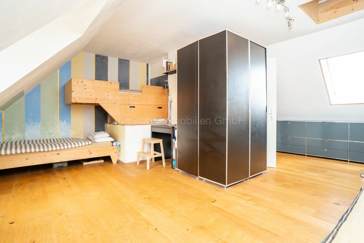 Dachzimmer mit Bett und Stauraum