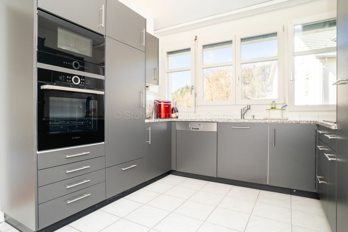 Moderne graue Küche mit großer Fensterfront