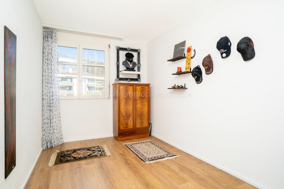 Helles Zimmer mit Fenster, Schrank und Wanddekoration