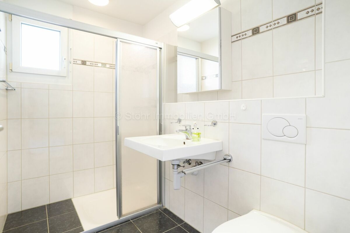 Helles Badezimmer mit Dusche und Wandwaschbecken