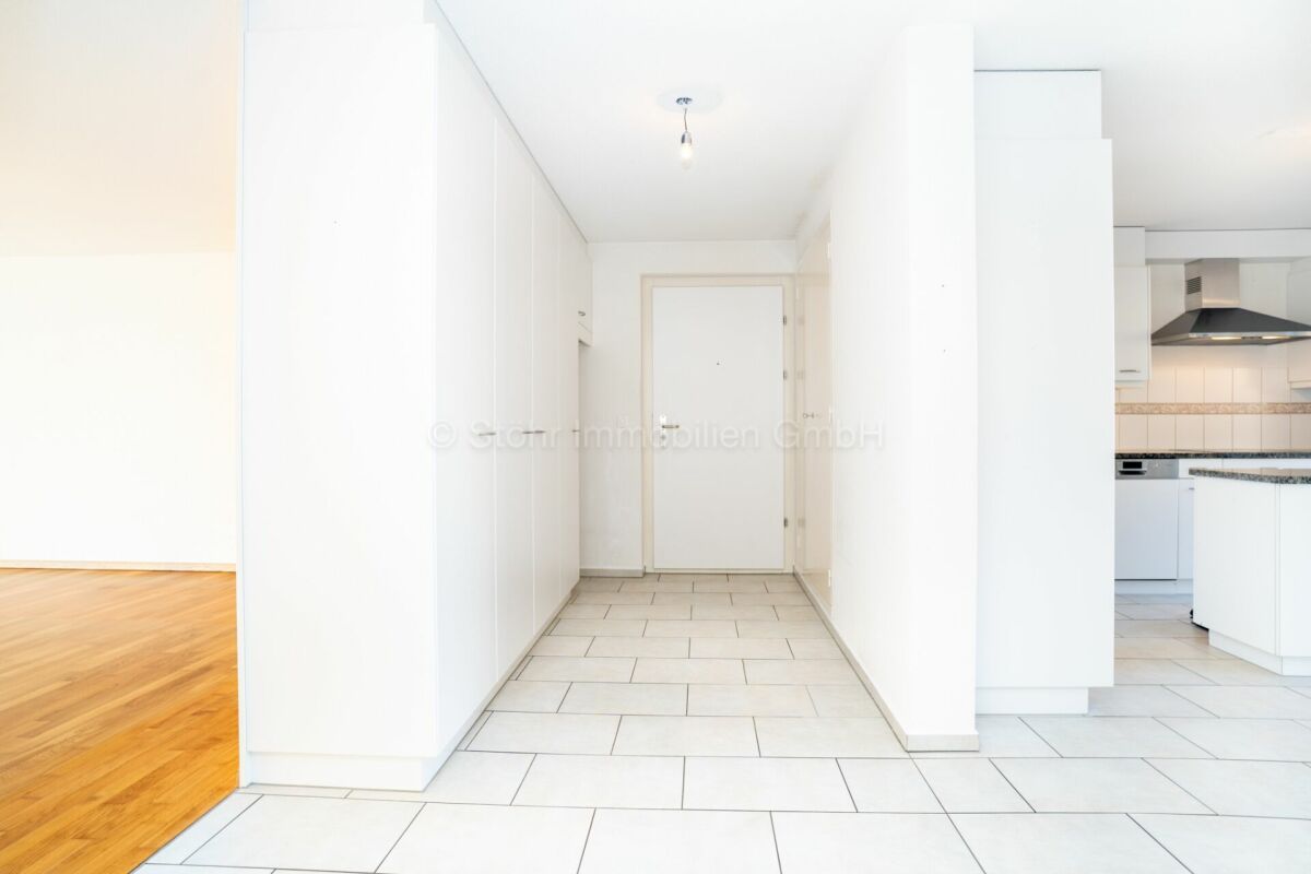 Heller Flur mit angrenzender Küche und Wohnbereich
