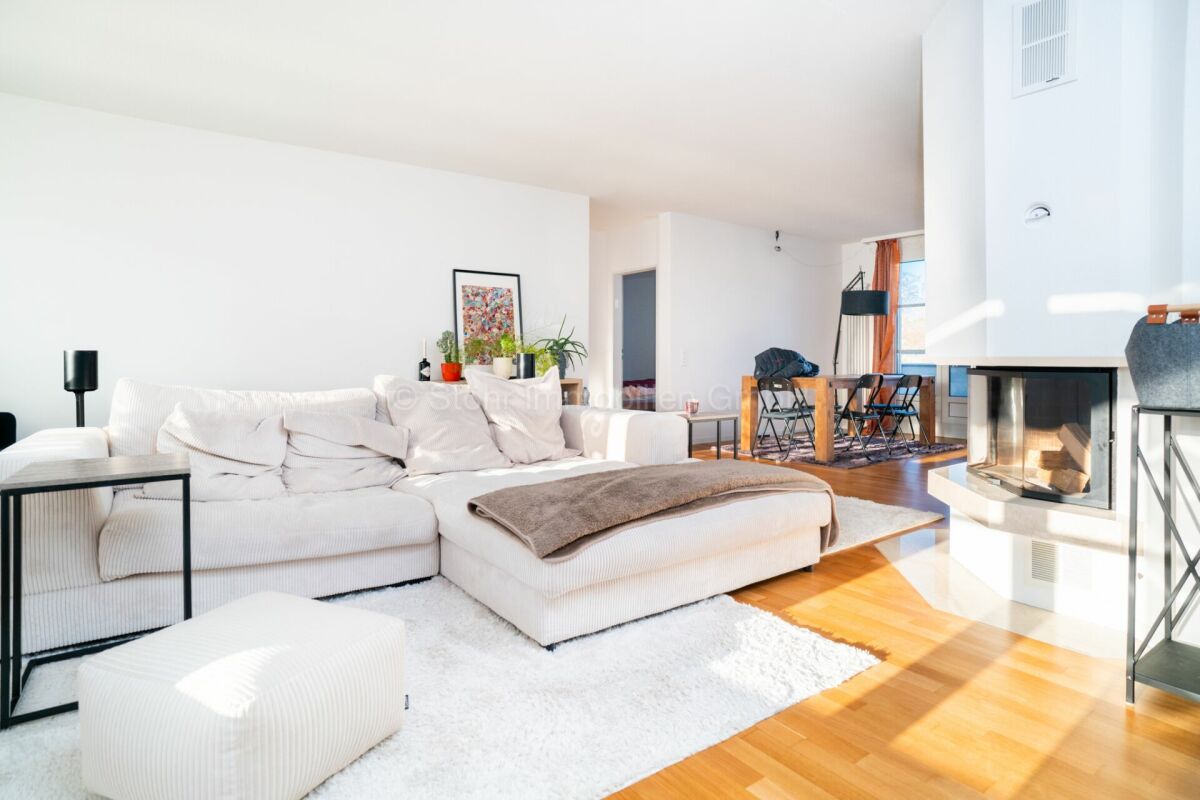 Helles Wohnzimmer mit Kamin und offener Esszone