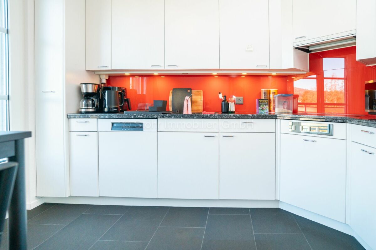 Moderne Einbauküche mit roter Rückwand