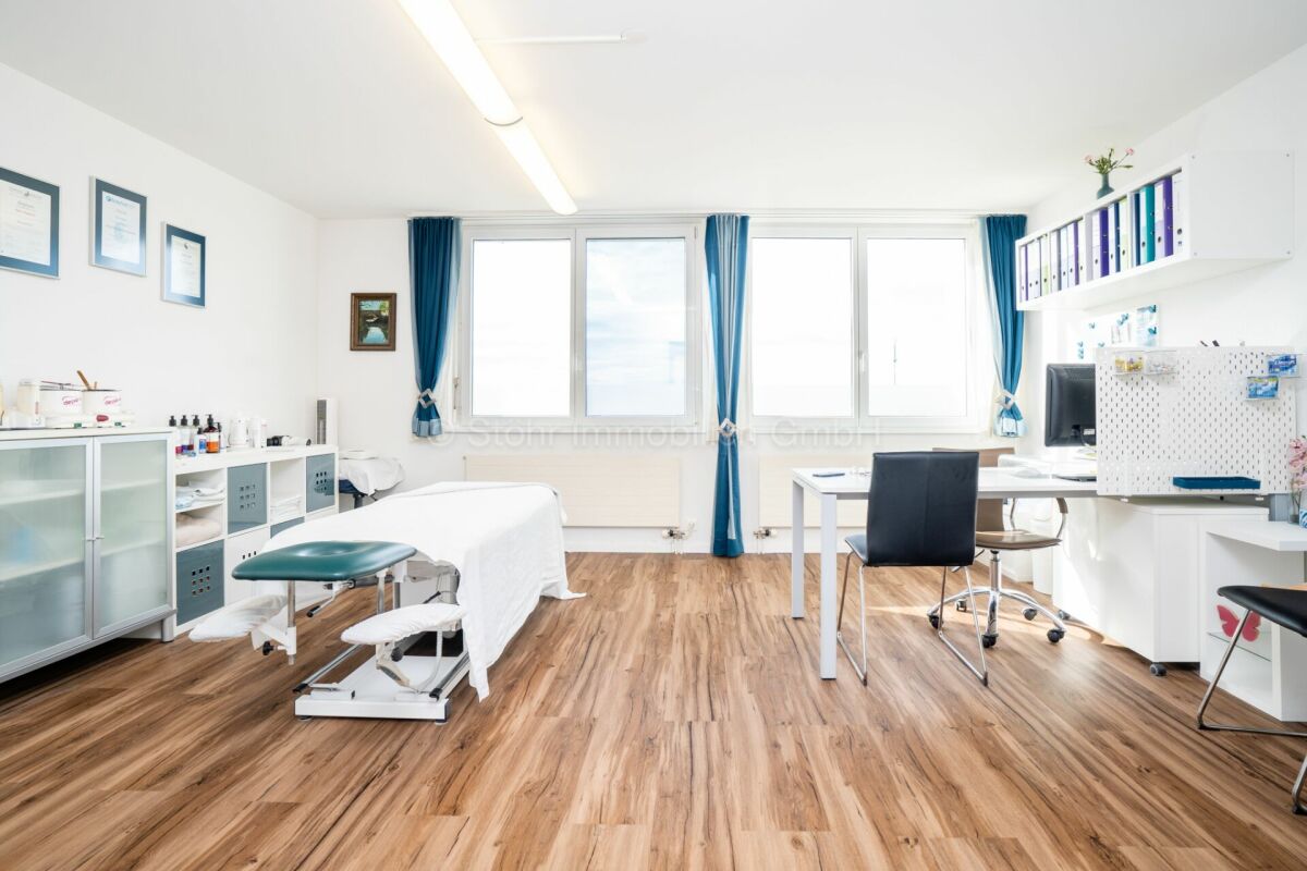 Heller Behandlungsraum mit Arbeitsplatz und Liege
