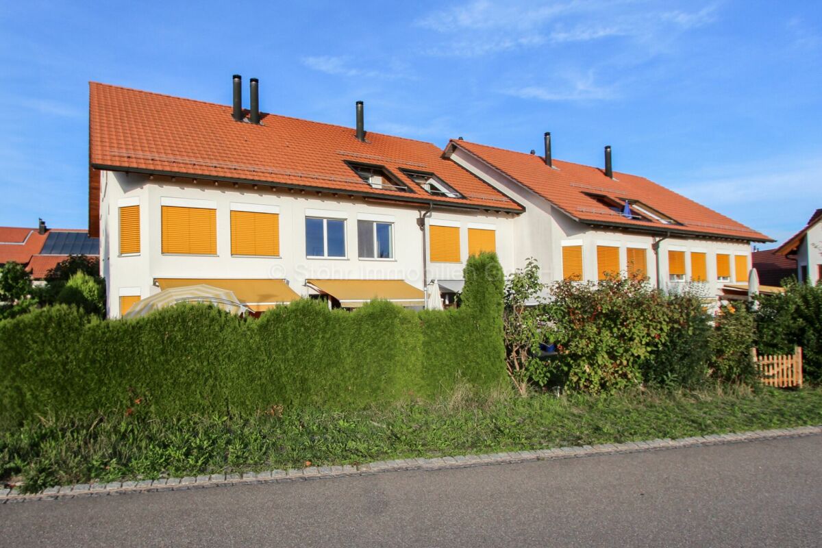 Reihenhaus mit rotem Ziegeldach und gelben Rollläden
