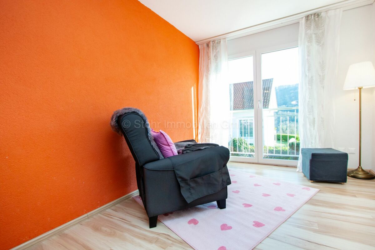 Helles Zimmer mit orangefarbener Akzentwand