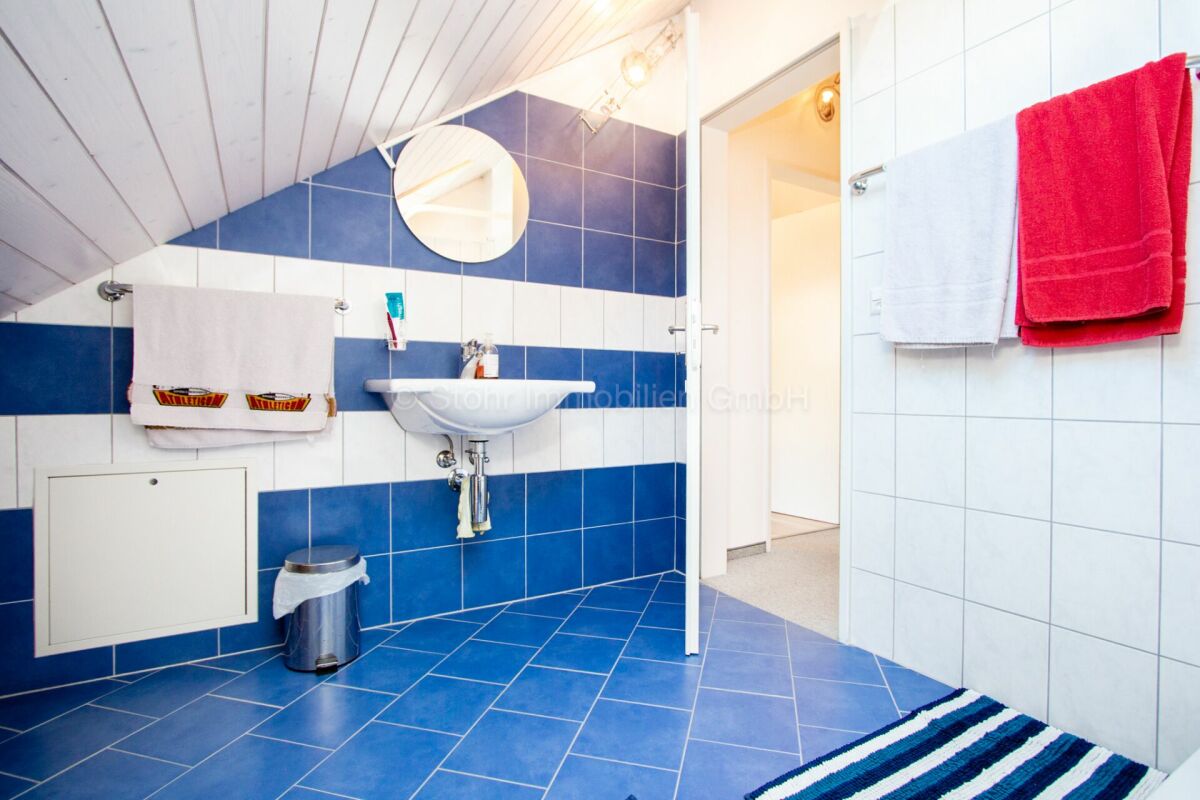 Badezimmer im Dachgeschoss mit blauen und weißen Fliesen