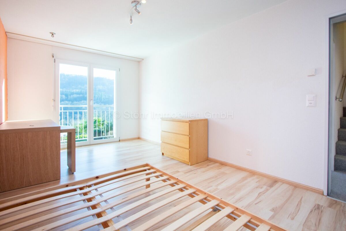 Helles, weitgehend leeres Schlafzimmer mit Balkonzugang