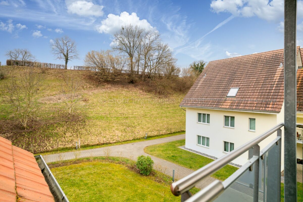 Blick vom Balkon auf Wohnhaus und Hanglage
