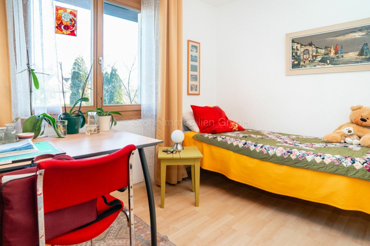 Helles Schlafzimmer mit Schreibtisch und Einzelbett