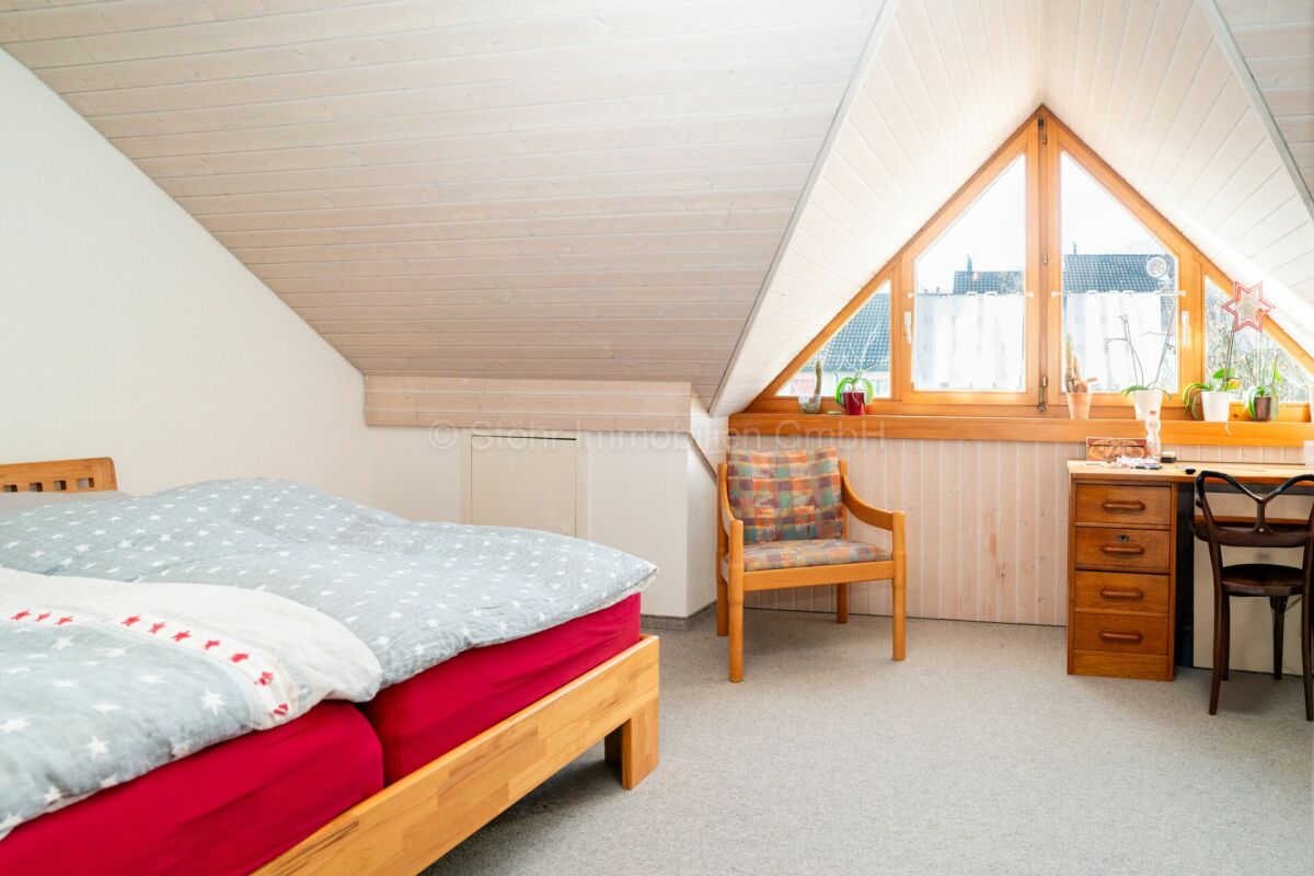 Dachzimmer mit Bett und Schreibtisch