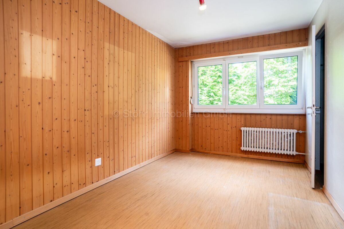 Heller leerer Raum mit Holzverkleidung und Fenster