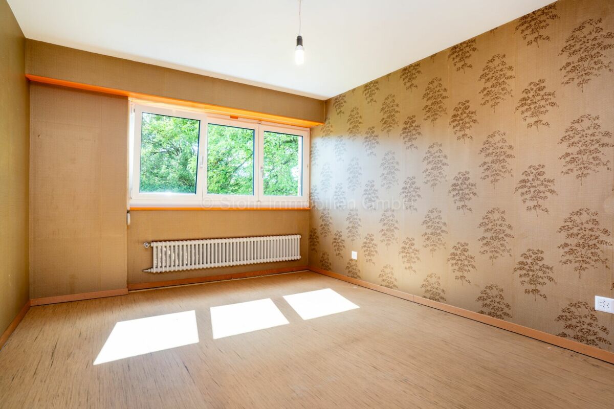 Leerer Raum mit Retro-Tapete und Fenster