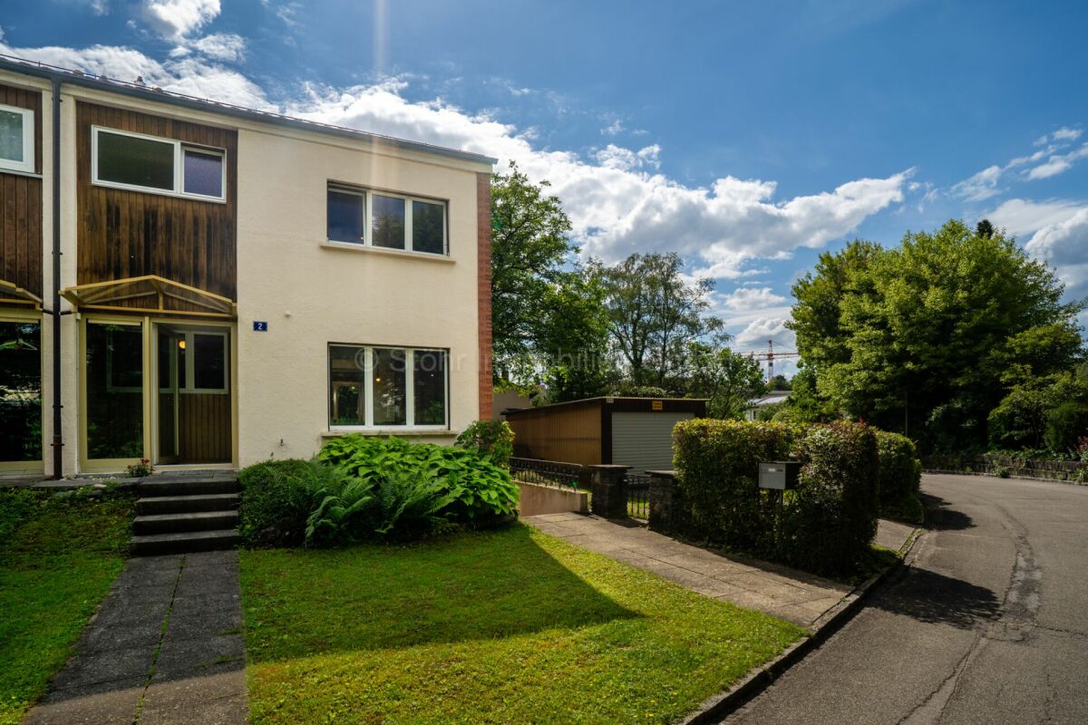 Wohnhaus mit Vorgarten und Straßenblick