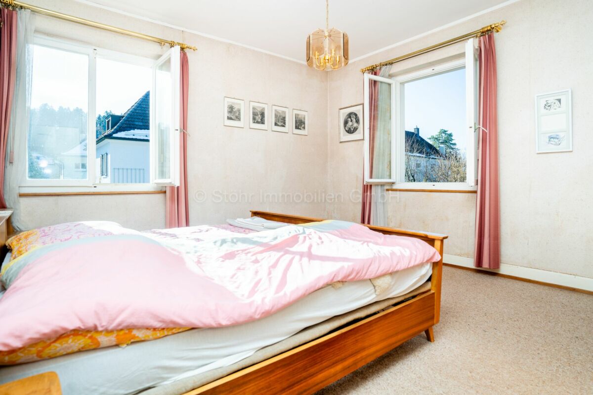 Schlafzimmer mit zwei Fenstern und Blick ins Freie