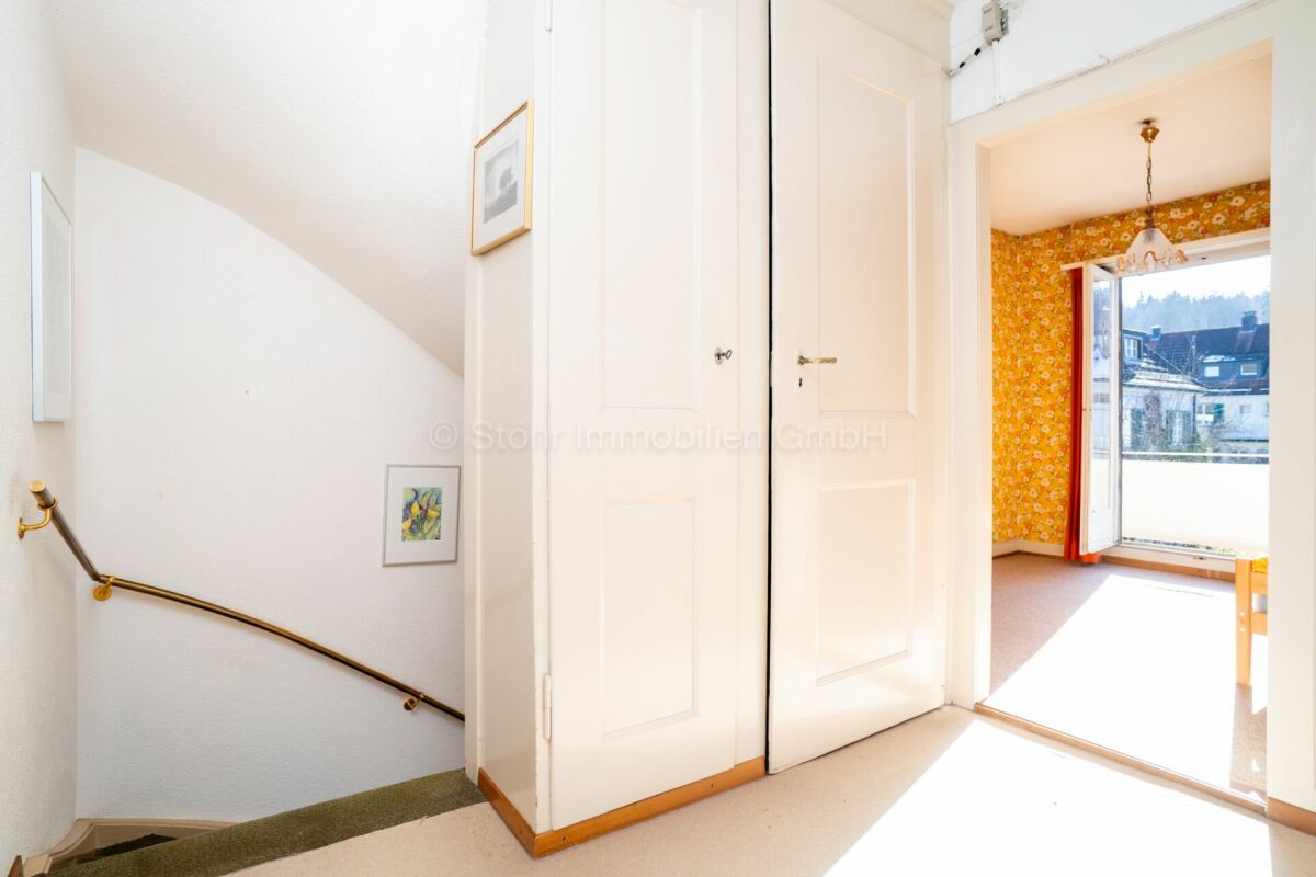 Heller Flur mit Treppe und offenem Zimmerblick