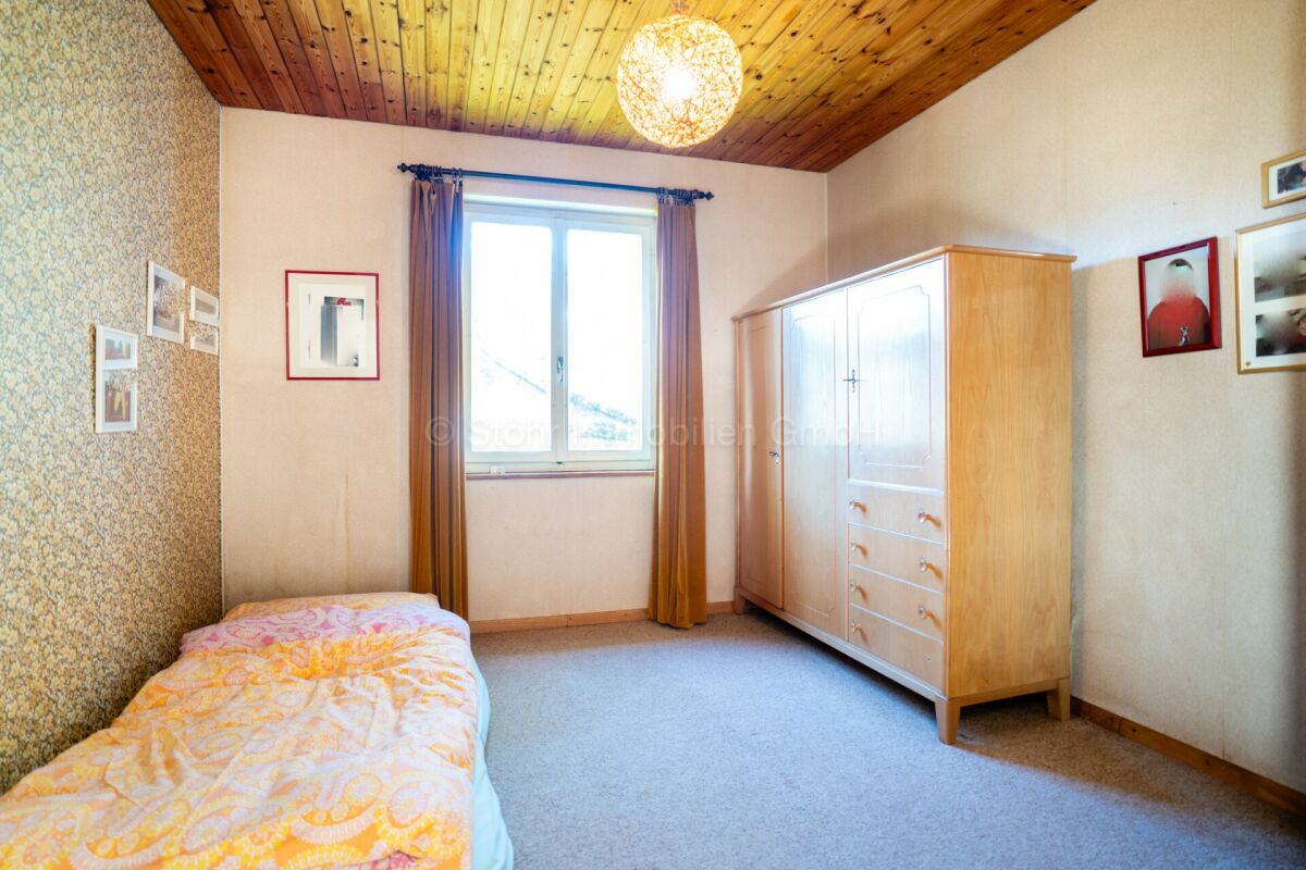 Kleines Schlafzimmer mit Holzdecke und Schrank