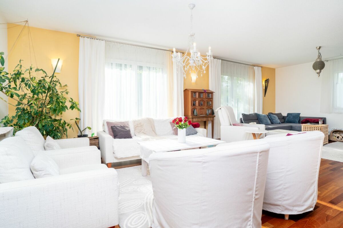 Helles Wohnzimmer mit weißen Sofas und gelber Akzentwand