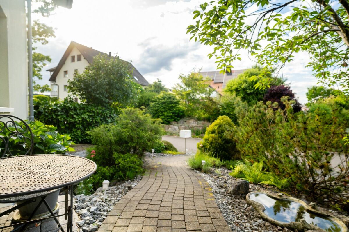 Gartenweg mit Terrasse und üppiger Begrünung