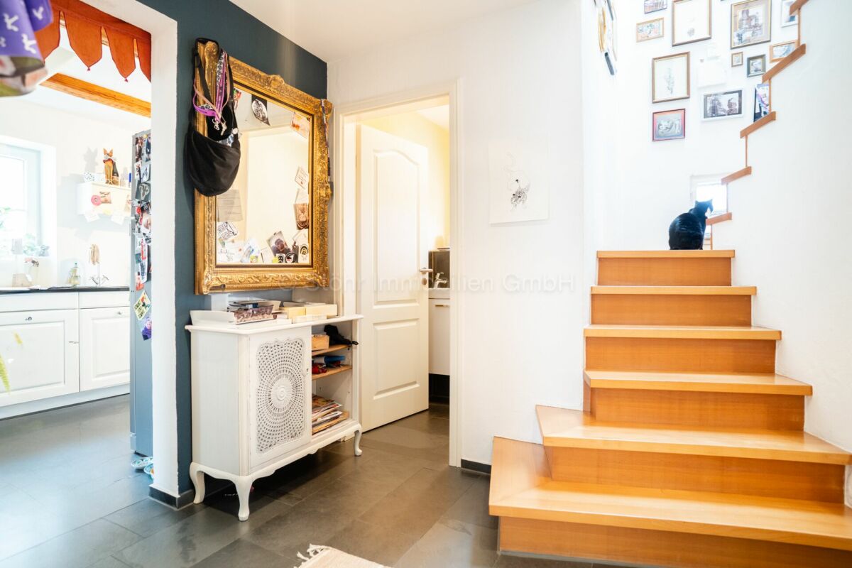 Flur mit Treppe und Blick in einen Nebenraum