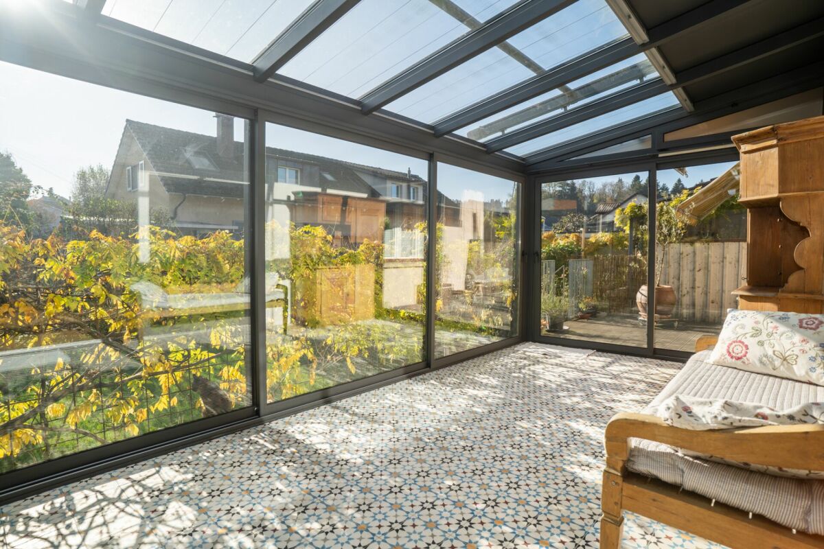 Veranda mit Glasdach und Gartenblick