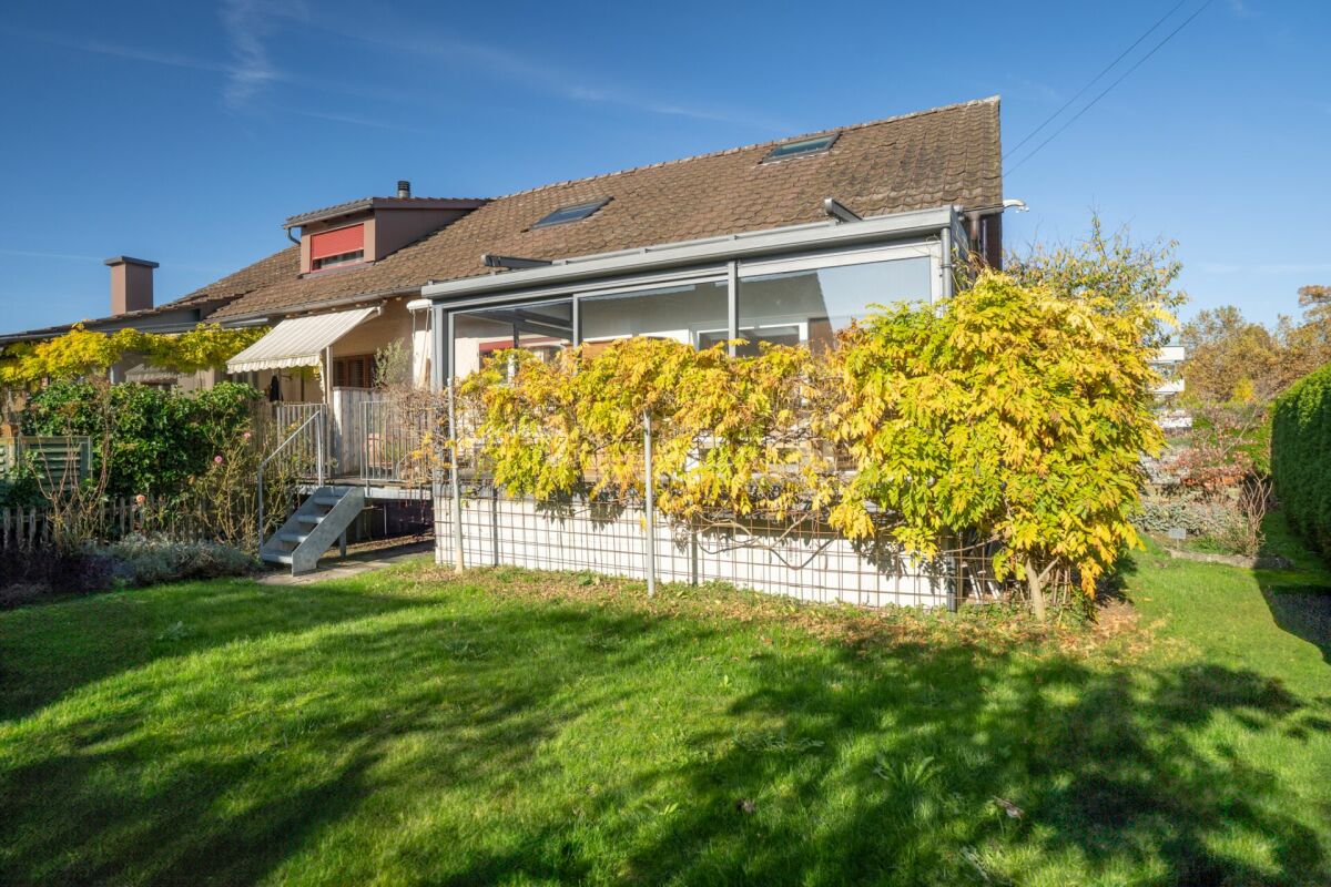 Gartenansicht eines Hauses mit Wintergarten