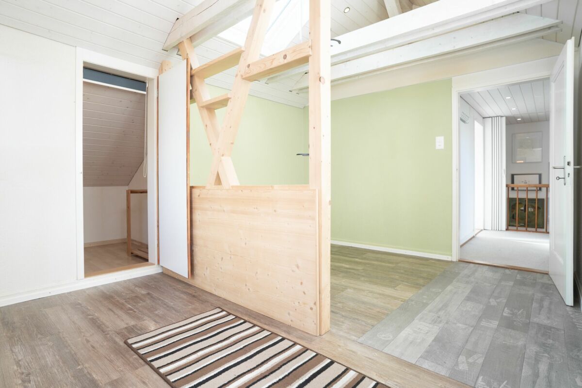 Heller Dachgeschoss-Flur mit offenem Holztreppenbereich
