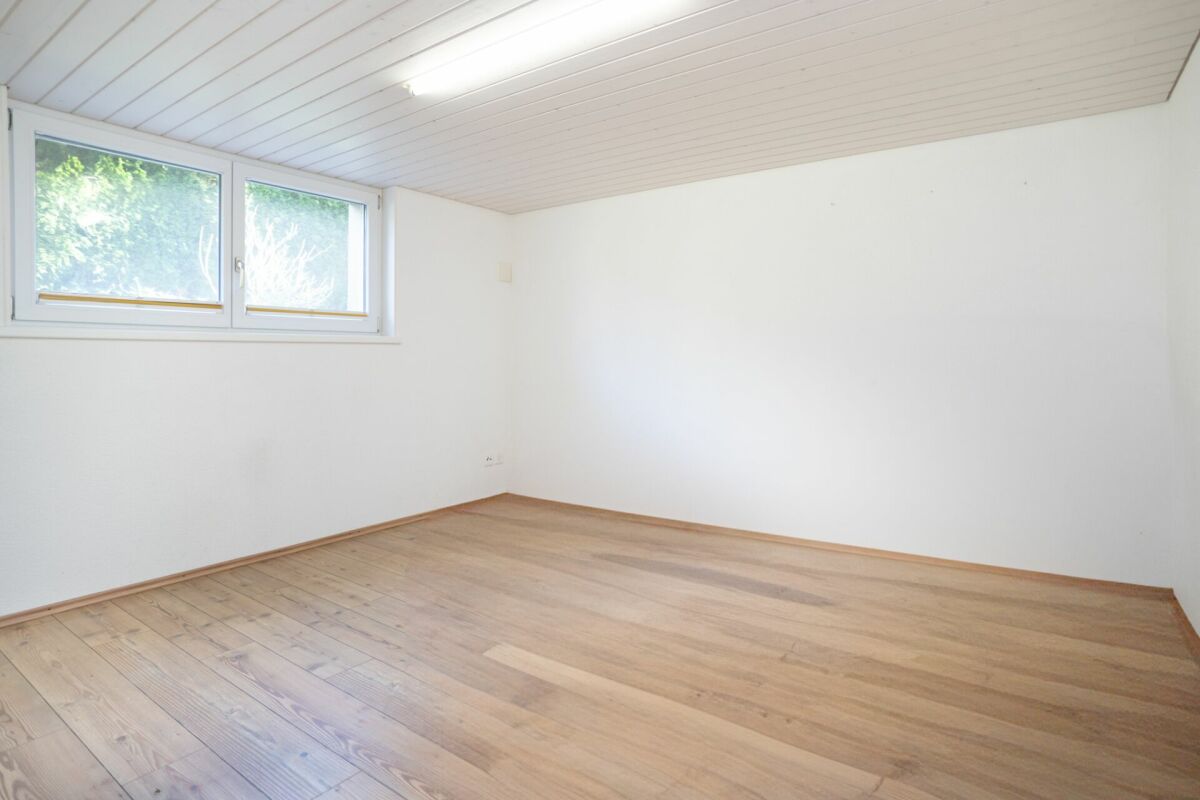 Heller leerer Raum mit Holzdecke und Fenster