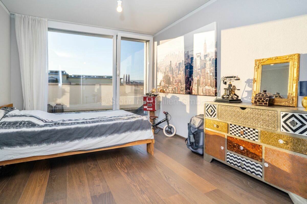 Schlafzimmer mit Stadtblick und dekorativem Sideboard