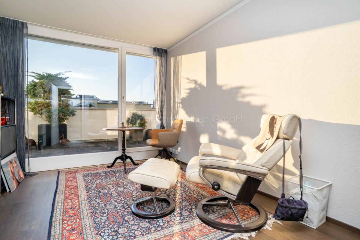 Helles Zimmer mit Balkon- bzw. Terrassentür und Sitzbereich