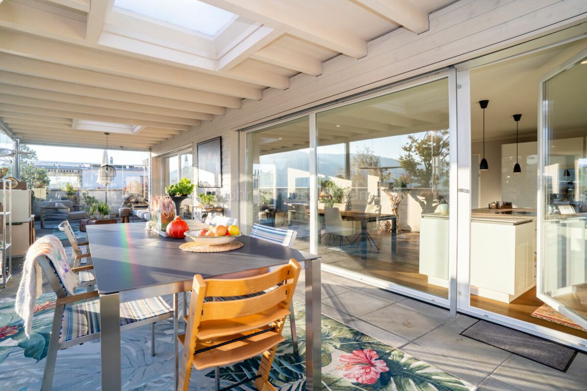 Überdachte Terrasse mit Essbereich und Blick in die Küche