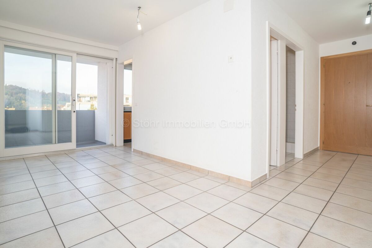 Heller leerer Wohnraum mit Balkon- und Flurzugang