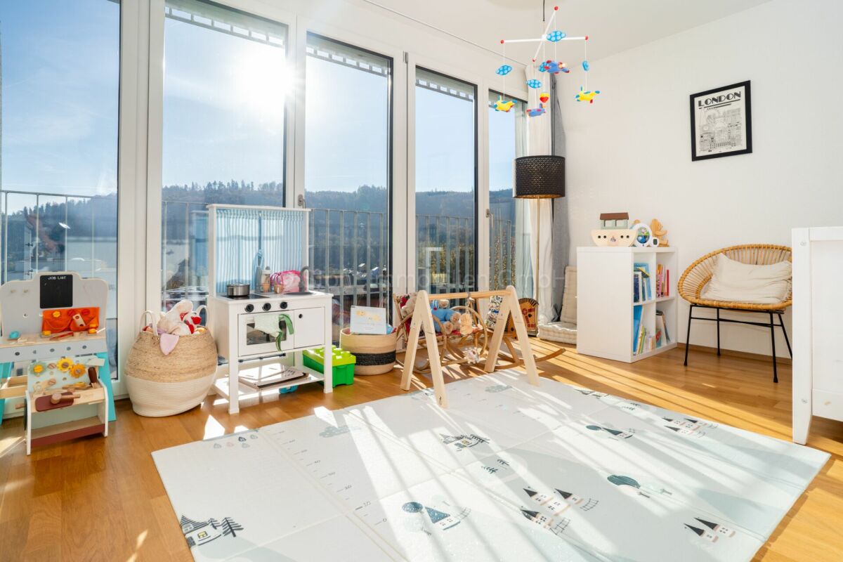 Heller Wohnraum mit Kinderbereich und Balkonblick