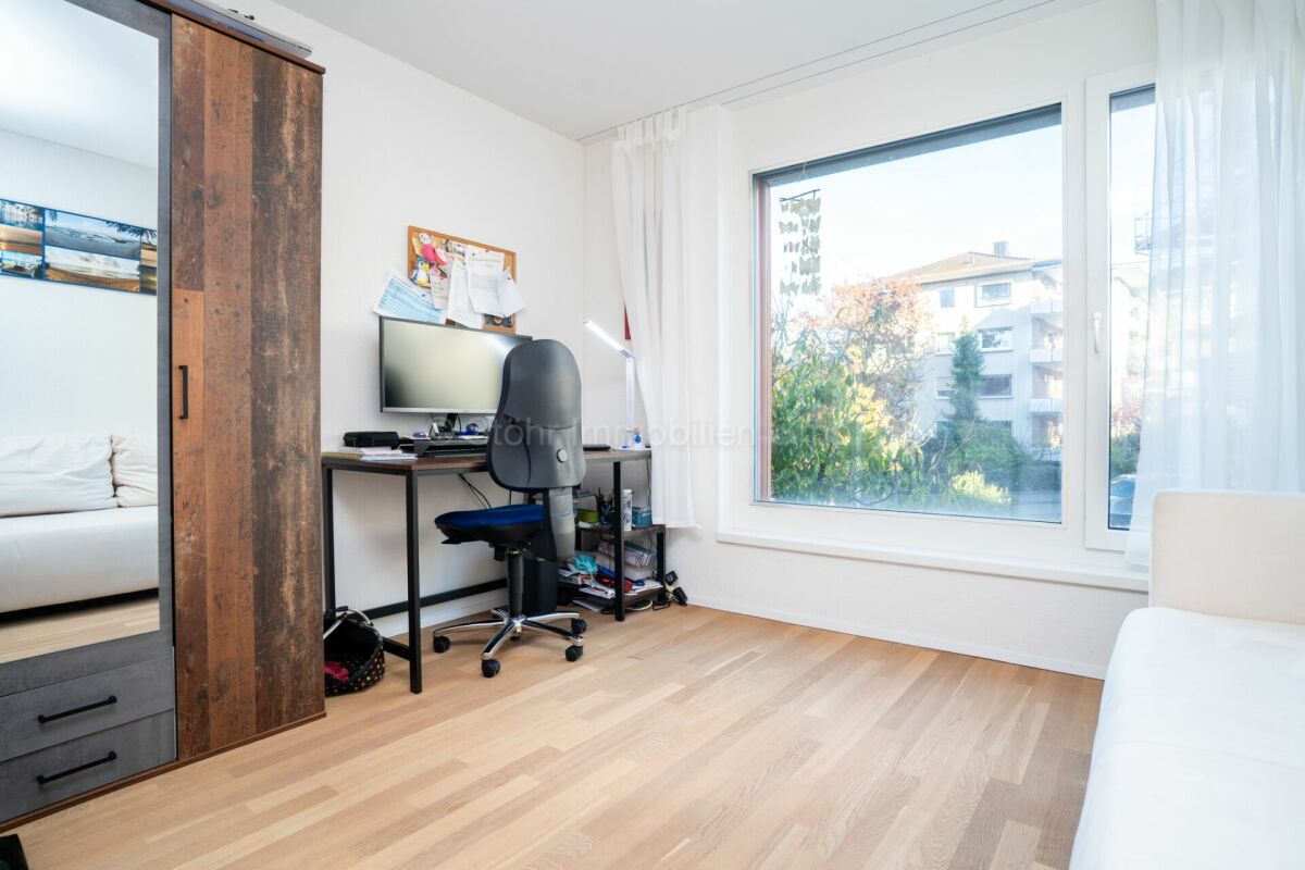 Helles Arbeits- bzw. Schlafzimmer mit großem Fenster und Schiebetürschrank