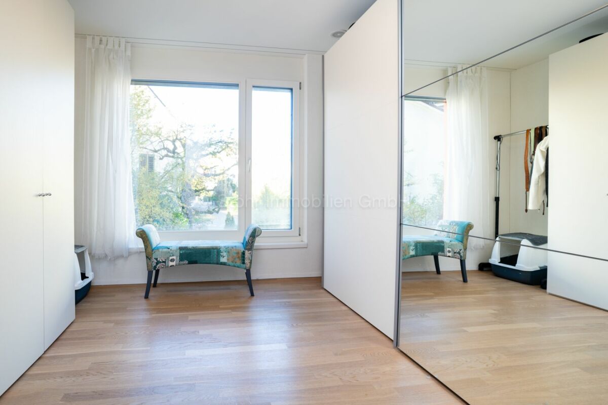 Helles Ankleidezimmer mit Fenster und Spiegel-Schrank