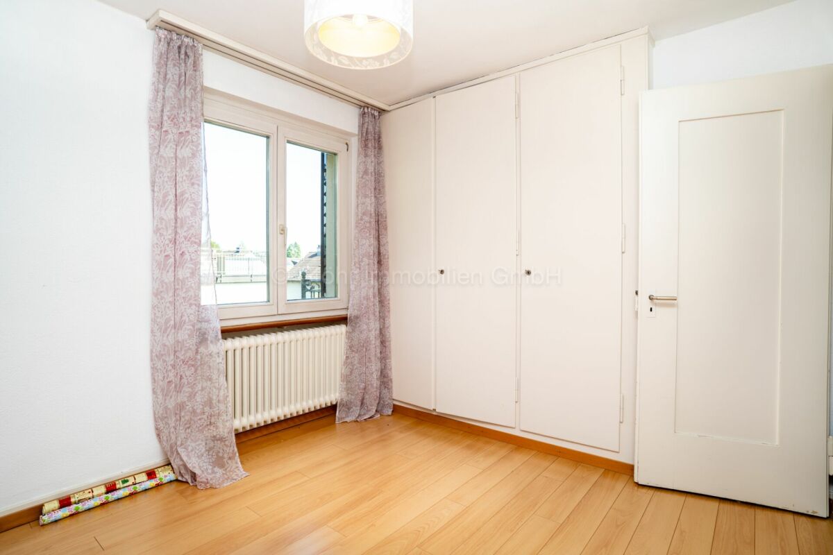 Heller, leerer Schlafraum mit Fenster und Einbauschrank