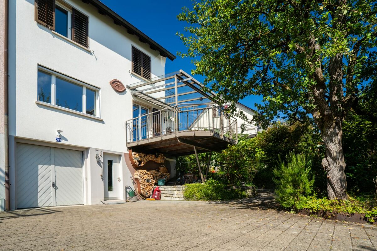 Außenansicht eines Wohnhauses mit Balkon und Garten
