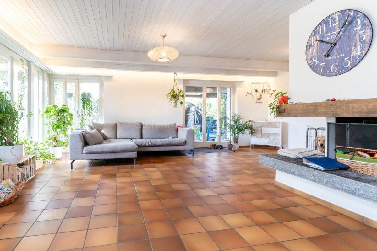 Heller Wohnraum mit Kamin und großer Fensterfront