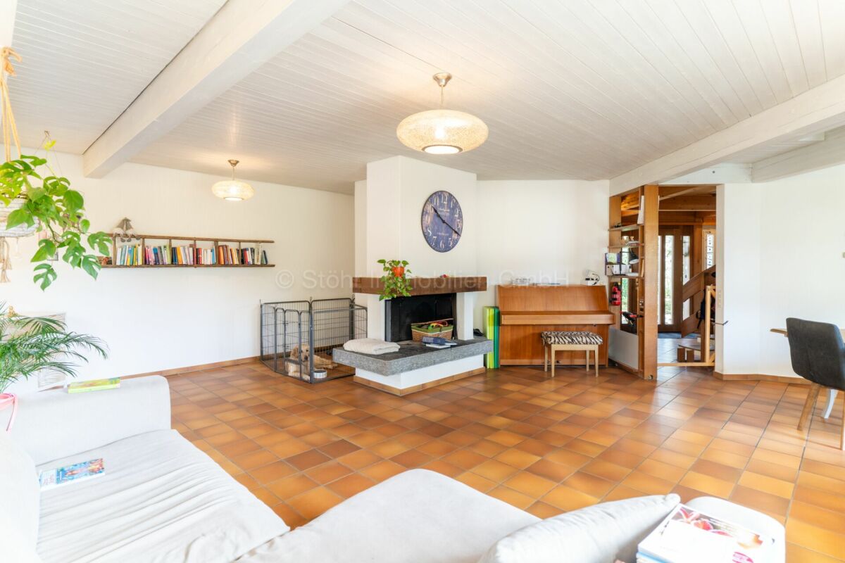 Heller Wohnraum mit Kamin und Klavier