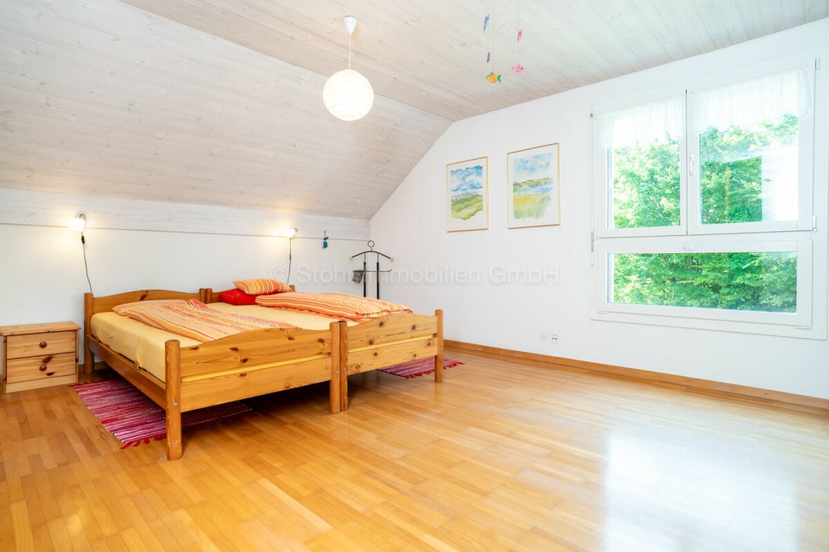Helles Schlafzimmer mit Holzbett und Dachschräge