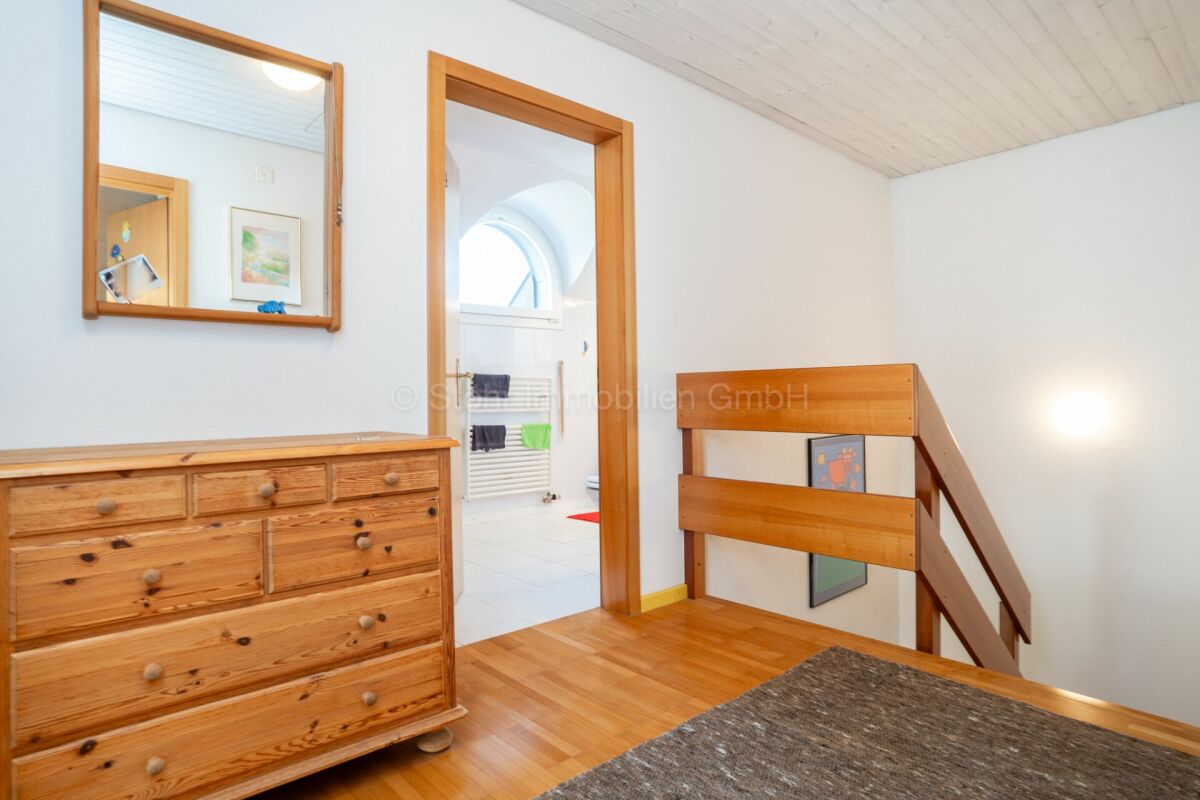 Treppenflur mit Holztreppe und angrenzendem Bad