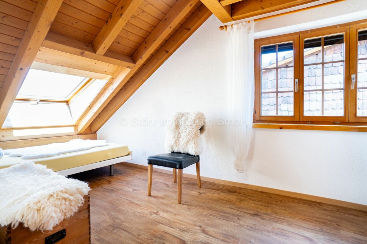 Dachzimmer mit Holzbalken und Dachfenster