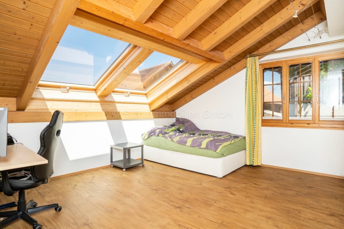 Dachgeschoss-Schlafzimmer mit Holzsichtdach