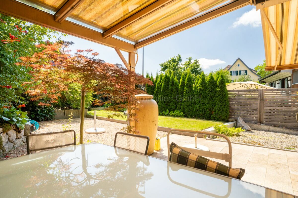 Überdachte Terrasse mit Gartenblick