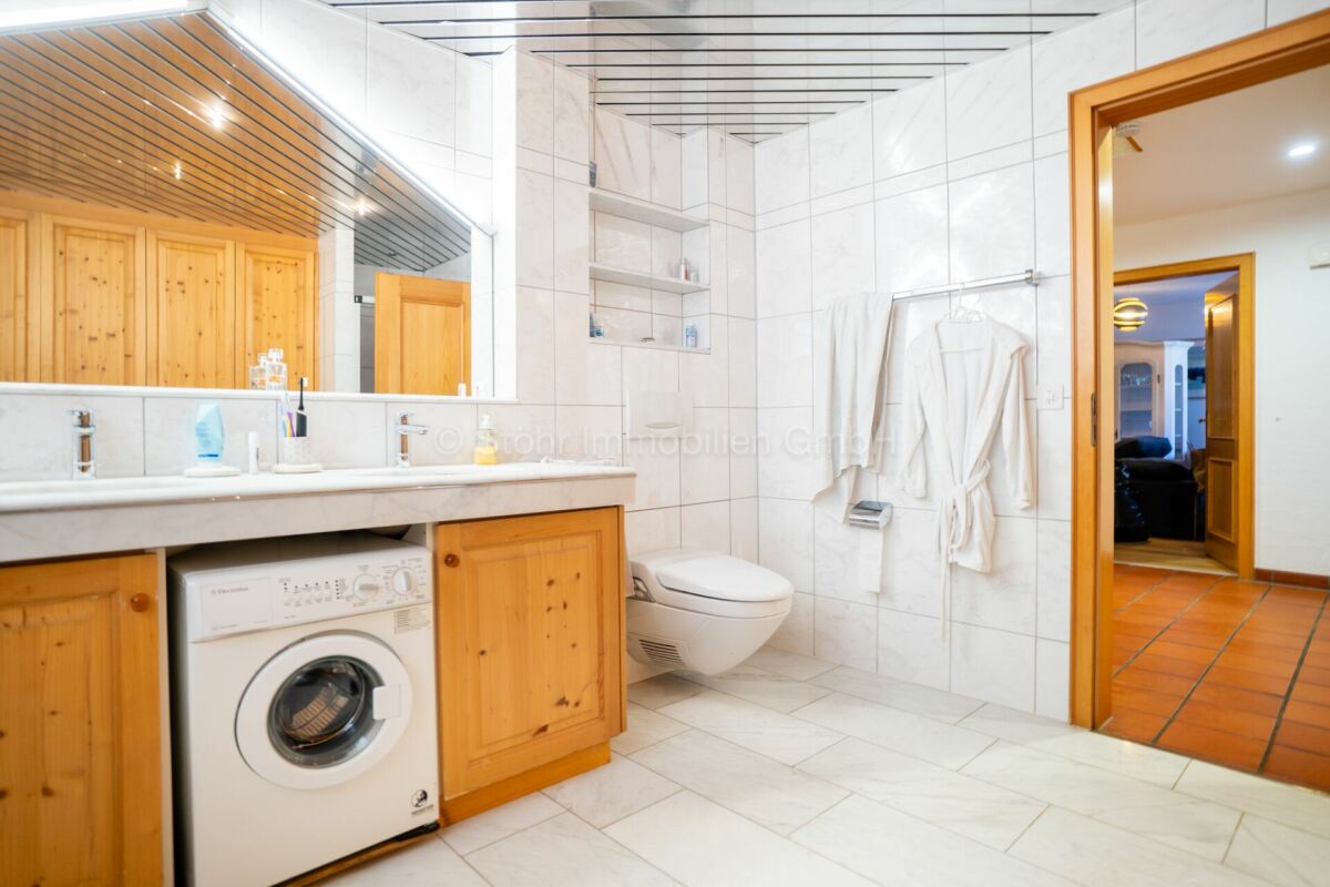 Badezimmer mit Waschtisch, WC und Waschmaschine