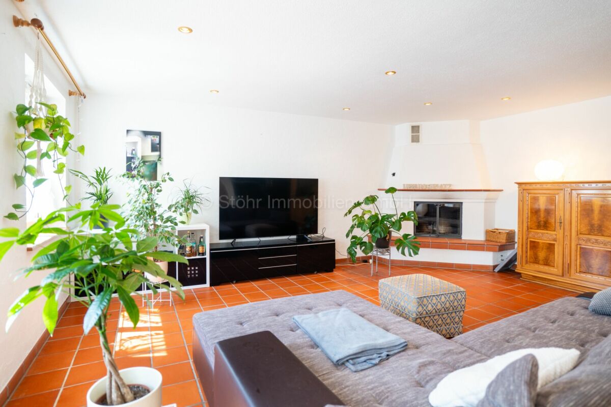 Helles Wohnzimmer mit Kamin und Terrakottaboden