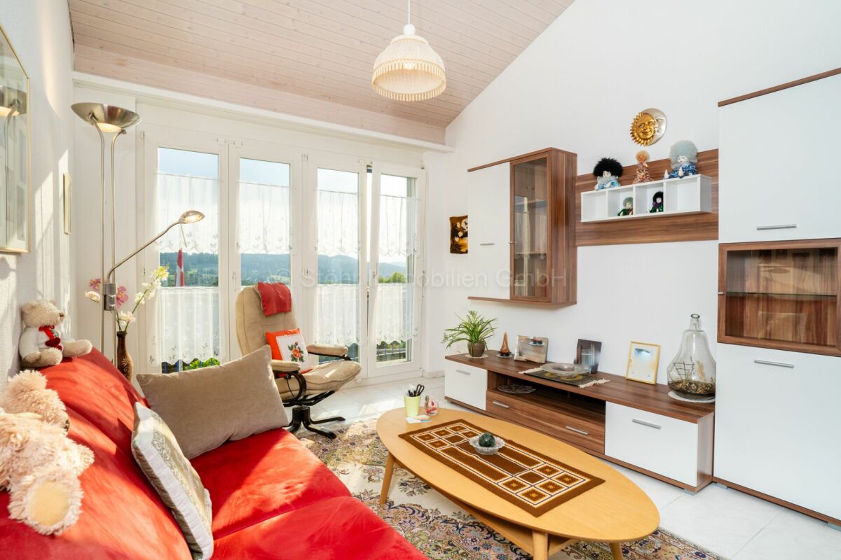Helles Wohnzimmer mit Dachschräge und Balkon-/Terrassentüren
