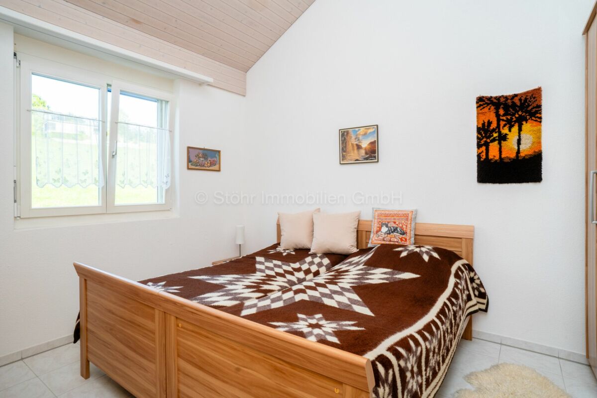 Helles Schlafzimmer mit Holzbett und Fenster