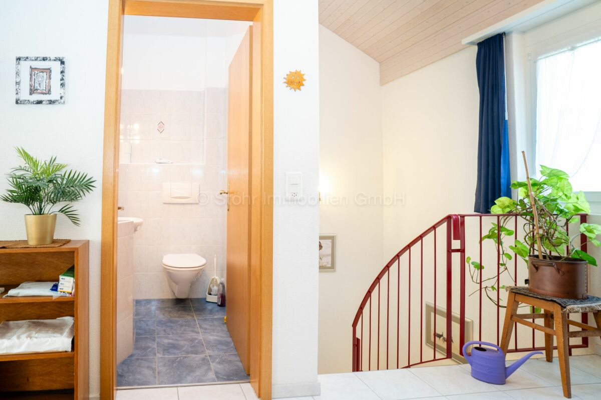 Heller Flurbereich mit offener Treppe und Gäste-WC