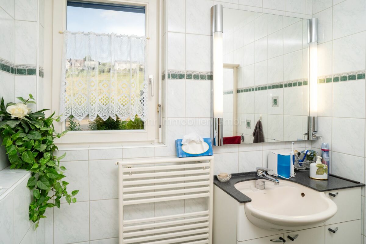 Helles Badezimmer mit Waschplatz und Fenster